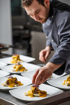 Un cuisinier prepare les assiettes